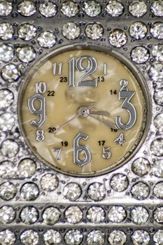Silver colored watch face with diamonds top view in macro