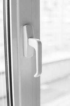 Close-up on a white handle of the pvc window