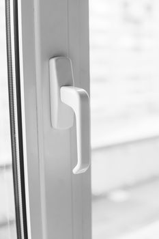 Close-up on a white handle of the pvc window