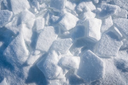 Closeup ice that covered with white snow. Water in the lake became frozen during winter period. Lake Baikal, Russia
