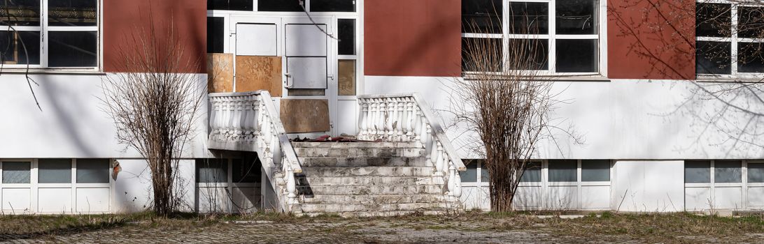 Front entrance doors of an empty and abandoned office building on a bright Sunny day. The concept of the financial crisis, the transition from working in offices to working at home.