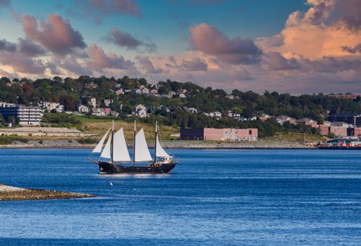 Large Black Schooner with White sails on blue water