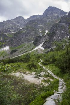 Hichhiking road near Alpine mountain lake. Europe, Alps