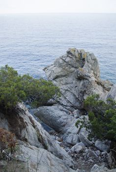 Rocks on the coast of Lloret de Mar in a beautiful summer day, Costa Brava, Catalonia, Spain. Waterfront of Lloret de Mar Costa Brava Spain. Rocks on the coast of Lloret de Mar