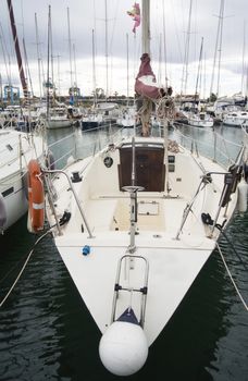 Boat In Valencia Port At Mediterranean Sea. Reflexion in the water. White yacht are in the Spanish port of Valencia in the beginning of spring. Cloudy sky