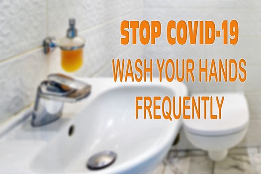 A text that reminds you of hygiene. Hand washing helps in fighting bacteria and preventing the COVID-19 virus. Blurred background of the bathroom interior.