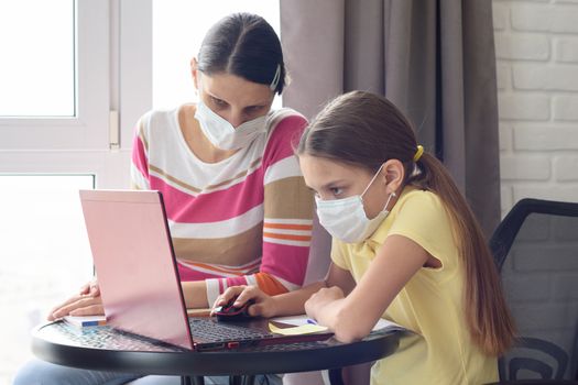 Quarantined mom and her child do homework online