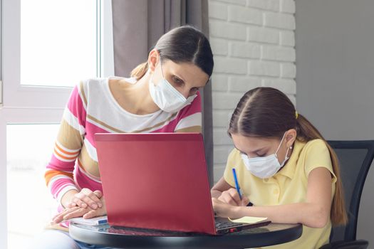 Mom and daughter jointly understand online services for distance learning