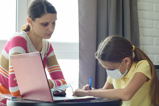 Mom helps to do homework for a sick child through distance learning