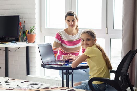 The tutor is teaching the child, both looked into the frame