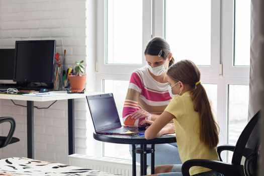 Mom helps daughter do homework, both in medical protective masks