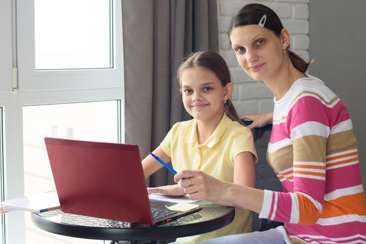 Girl and mother undergo interactive online education at home