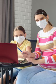 Portrait of a family in front of a laptop screen in medical masks