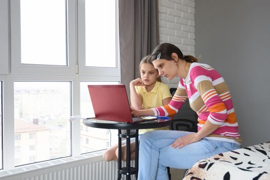 Mom helps her child learn online learning at home