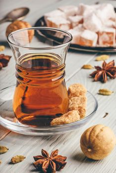 Tea in armudu with turkish delight Rahat Lokum and different spices over wooden surface