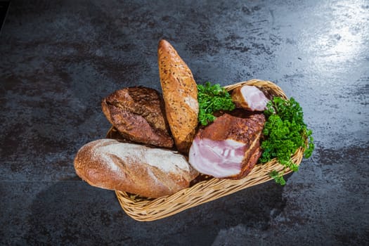 Still life. Bread and smoked meat in a braided basket on the table.
