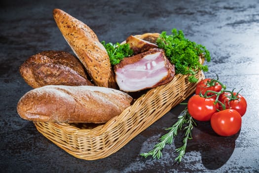 Still life. Bread and smoked meat in a braided basket on the table.