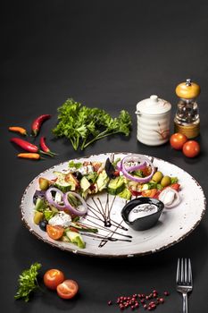 Vegetable salad on a white dish on a black background