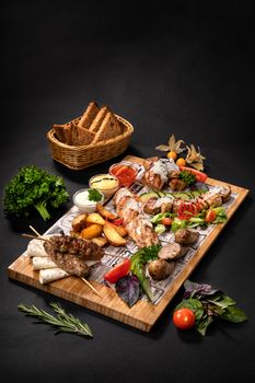 Meat assorty with kebab, salad, vegetable cut on a wooden board.