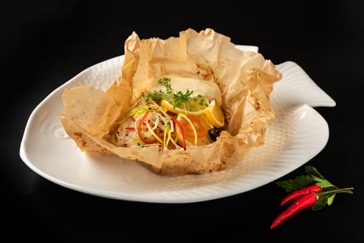 White fish fillet baked in paper parchment and pepper chili