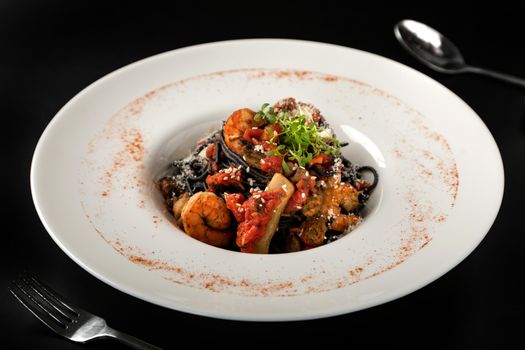 Seafood, Mediterranean cuisine. Black paste with squid ink, with squid meat, crab, shrimp and fish.