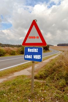 Covid-19 road sign, stay at home against the backdrop of the countryside