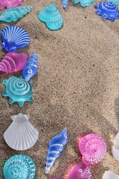 summer background and concept of beach with sand and artificial seashells
