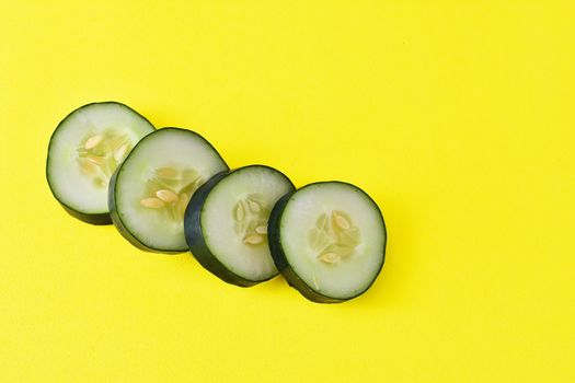sliced ​​cucumber on yellow background
