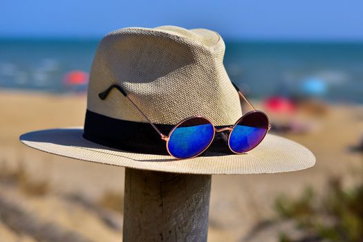 hat hanging on the beach with glasses