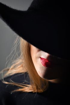 A Woman With Red Lips In A Black Hat On A Black Background