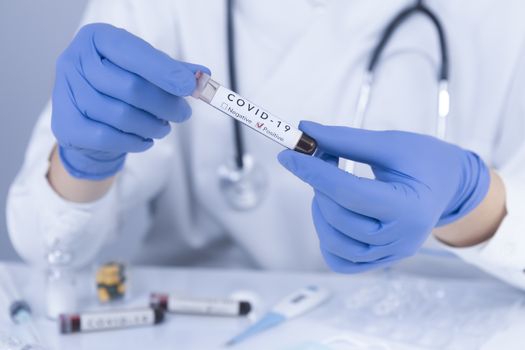 Doctor hands with protective gloves analyzing COVID 19 Coronavirus test blood. Virus test and research concept. Closeup