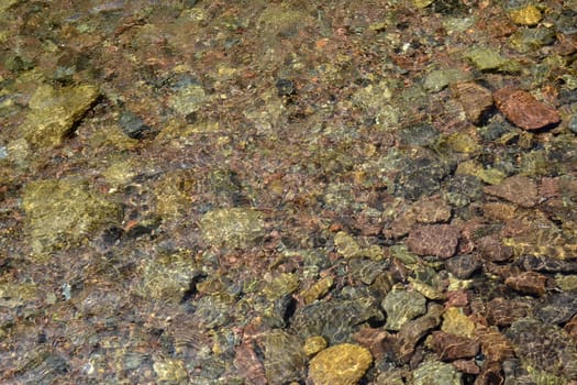 Colourful pebbles under water background pattern for design