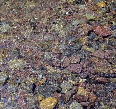 Colorful pebbles under water background