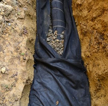 Water drainage system on a construction site with drainage tube and geotextile