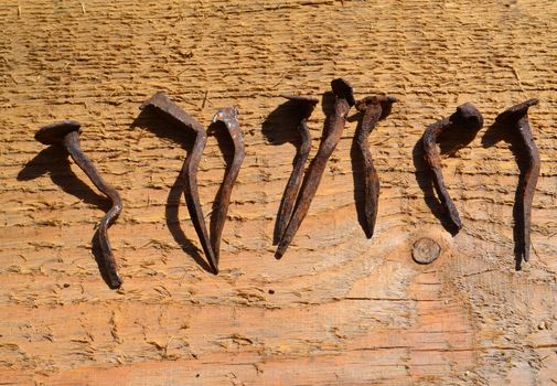 Old hobnails on wooden background