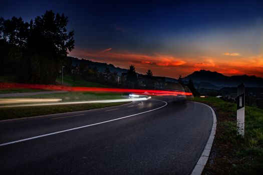 streaks of car lights during sun down in Switzerland