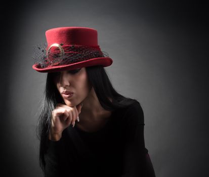Elegant woman in red vintage hat are thinking