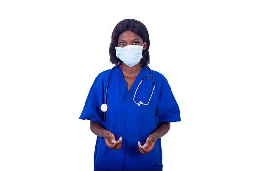 a young nurse in a blue coat standing on a white background with a mask and stethoscope ready for work
