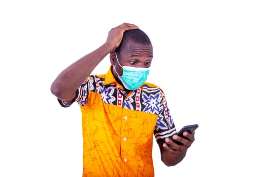 surprised young man wearing medical mask on his face looking at the mobile phone.