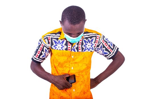 handsome young man wearing medical mask, sad holding cellphone and looking down.