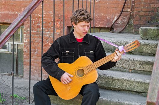 Guitarist playing his guitar of classical musical instrument on the street.