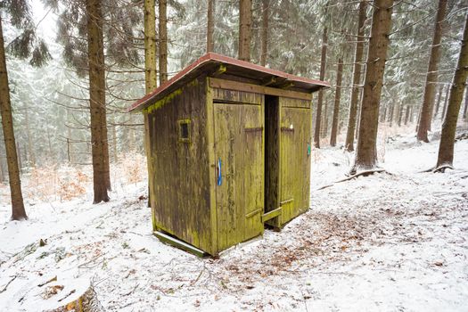 Wood cabin toilet in the snow in the woods