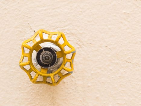 Yellow faucet front view isolated on soft backlight. Hydraulic valve.