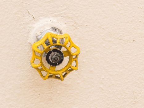 Yellow tap isolated on light background.Hydraulic valve.