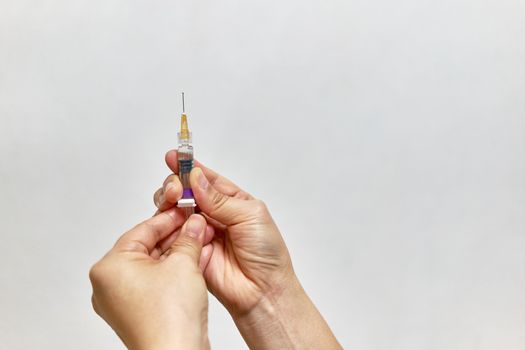 Hand of nurse holding hypodermic syringe vaccine of flu with white background and copy space.