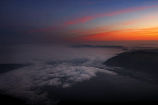 fog in the valley during sunrise. Photo taken from mount Rigi with red glowing sky