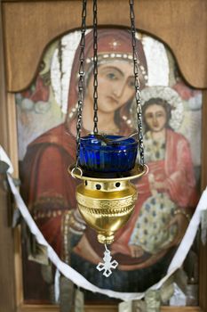 Close up of a hanging brass and class candle holder hanging in an Orthodox Church, Crete, Greece.