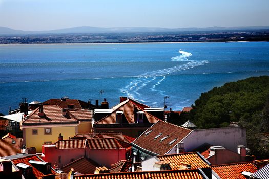View above city of Portugal with river with boat crossing the river
