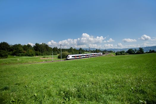 Landscape Photographic- with train, moving along Zugersee with a train passing by