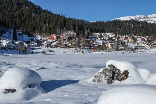 Mountains in winter at Laax ski resort, with snow on frozen lake